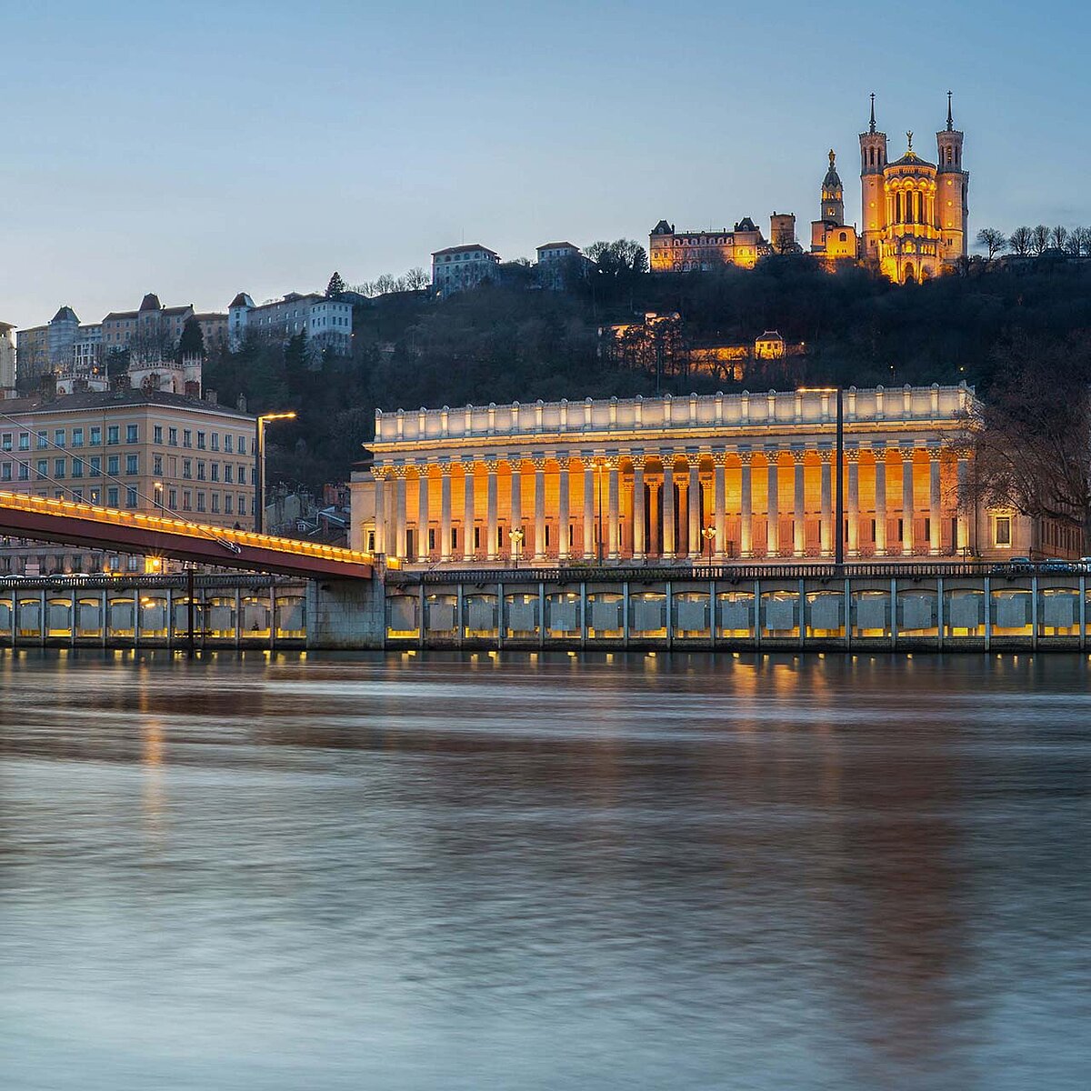 River with historical bridge and building in the evening